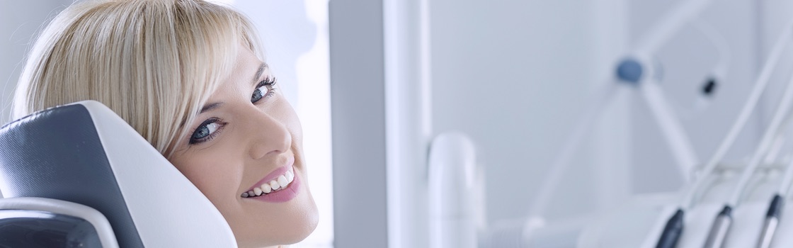 woman sitting in a dentists office about to get her teeth examined