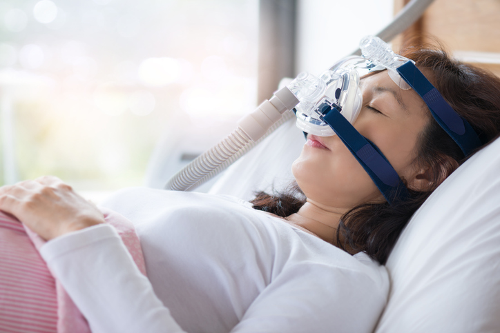 woman sleeping wearing cpap device